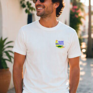 Wit T-shirt met klein “The Game Changer club” logo op de linker borst, gedragen door een lachende man in een zonnige straat