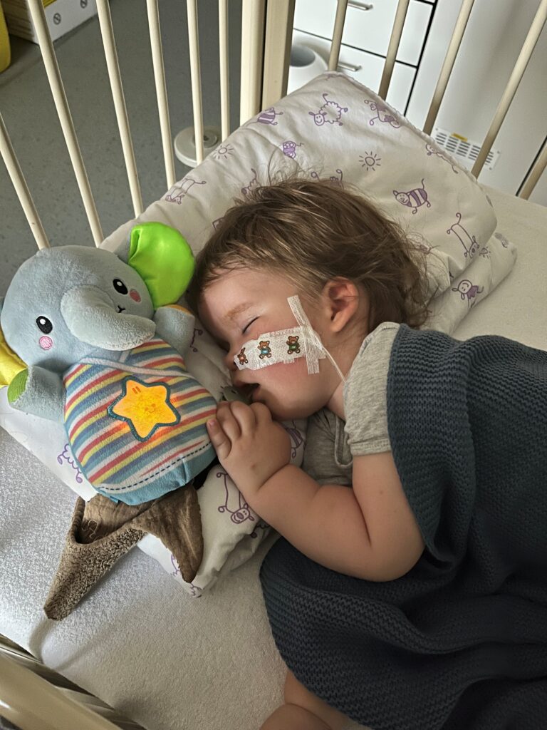 Adriaan slaapt in een bedje met een neussonde en een lichtgevende olifantenknuffel naast zich